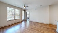 Located at 591 Jackie Moore Lane in Canton, GA, this one-bedroom, one-bathroom unit offers a well-designed, single-floor layout with generous living space. The open-concept kitchen and living area serves as the heart of the unit, featuring light hardwood-style flooring, recessed lighting, and a ceiling fan. The kitchen is outfitted with crisp white cabinetry, a herringbone tile backsplash, granite countertops, stainless steel appliances, and a central island with a built-in sink — ideal for both cooking and casual dining. The living room receives abundant natural light through large windows and a glass door that opens to a private balcony with outdoor views.

The bedroom is carpeted for comfort, includes a ceiling fan, and is served by a window that brings in natural light. Two walk-in closets with wire shelving systems provide substantial storage. The bathroom features a dual-sink vanity with granite countertops, white cabinetry, and hardwood-style flooring. Throughout the unit, neutral tones and clean finishes create a cohesive, modern aesthetic well-suited to everyday living.