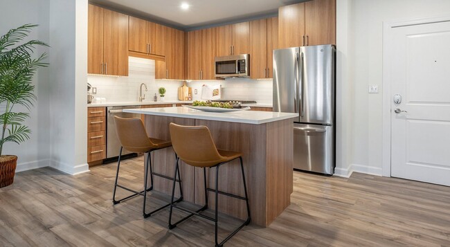 Two stools tuck under the island end, clear of the work triangle. - Arlington 360