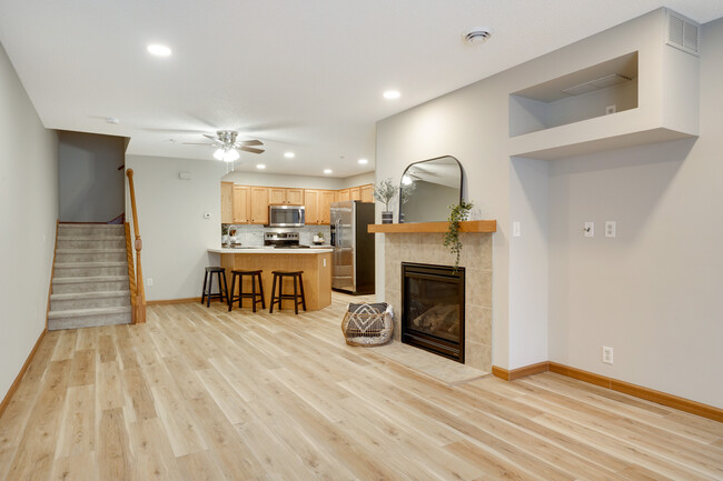 Main level - Family room with gas fireplace, looking toward kitchen and stairway - 16386 Elm Creek Ln