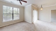 Located at 102 Elizabeth Sarah Blvd in Greer, SC, this single-floor, one-bedroom, one-bathroom residence offers a thoughtfully organized layout across a compact and efficient footprint. The entrance leads into a well-designed interior with distinct spaces for living, sleeping, and daily routines.

The kitchen is a functional highlight, featuring warm honey-toned wood cabinetry, dark countertops, and a full suite of black appliances including an electric range, built-in microwave, dishwasher, and refrigerator. Wood-look flooring runs throughout the kitchen, adding warmth and durability. A peninsula provides additional counter space and a natural transition point within the open layout.

The bedroom is a comfortable retreat, finished with soft wall-to-wall carpeting, crown molding, and a ceiling fan. Multiple windows invite natural light and provide views of the surrounding greenery, while a sliding glass door adds an additional connection to the outdoors. A dedicated closet with wire shelving offers organized storage.

The bathroom is clean and practical, complete with a tub-shower combination with tiled surround, a vanity with a countertop sink, and a large mirror. Wood-look flooring continues here, tying the aesthetic together.

A separate laundry area with utility hookups and additional closet space round out this efficiently designed residence.