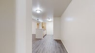 This single-floor unit in Oakley, California, 94561, offers a clean and functional layout with consistent finishes throughout. The open living and dining area features durable grey wood-look flooring, neutral white walls, and a large picture window fitted with vertical blinds that allows natural light to fill the space while offering views of the outdoor surroundings. A peninsula counter connects the living area to the kitchen, creating an open and accessible flow between the two spaces.

The galley-style kitchen is well-equipped with light wood cabinetry, granite-look countertops, a double sink, a white dishwasher, a freestanding range with oven, and a full-size refrigerator. The wood-look flooring continues seamlessly into the kitchen, reinforcing the cohesive aesthetic.

Both bedrooms are carpeted in a neutral tone and feature windows with vertical blinds that bring in natural light. One bedroom includes a sliding closet with built-in hanging storage, while another offers additional versatility. The two bathrooms mirror each other in design, each featuring light wood vanity cabinetry, a white countertop sink, a framed mirror, and a tub-shower combination with tile surround, all set on wood-look flooring. The overall ambiance is bright, clean, and move-in ready.
