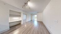 Located at 30 Shattuck Rd in Andover, MA, this well-appointed 2-bedroom, 2-bathroom residence offers a thoughtfully designed single-level layout with modern finishes throughout. The open-concept living and dining area is anchored by light wood-tone flooring, a built-in desk nook, track lighting, and sliding glass doors that open onto a private balcony with outdoor views. The contemporary kitchen features rich walnut-toned cabinetry, white quartz countertops, a tile backsplash, stainless steel appliances including a refrigerator, range, and microwave, and pendant lighting over the peninsula, which flows seamlessly into the main living space. Both bedrooms are carpeted and receive natural light through large windows with outdoor views. The primary bedroom includes a ceiling fan and direct access to one of the two bathrooms, which is finished with wood-toned cabinetry, white quartz countertops, and tile flooring. Three closets—including a generously sized walk-in with wire shelving—provide ample storage. Additional conveniences include a dedicated laundry area and a utility room. The clean, neutral palette and modern design elements create a bright, cohesive ambiance throughout the entire residence.