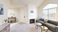This well-designed one-bedroom, one-bathroom residence in Seaside, California offers a thoughtful layout across a single floor. The living room serves as a welcoming gathering space, highlighted by a classic fireplace, soft carpeted flooring, and a striking arched window that frames views of the surrounding greenery and fills the room with natural light. Vaulted ceilings amplify the sense of openness throughout.

The kitchen is efficiently arranged with white cabinetry, granite-style countertops, a double-basin sink, a gas range, dishwasher, and a full-size refrigerator. A skylight overhead brightens the space naturally. Adjacent to the living area, a dedicated office provides a functional workspace with ample room for a desk and seating.

The bedroom is a comfortable retreat featuring vaulted ceilings, a bright window with garden views, plush carpet, and access to a walk-in closet with built-in shelving. The bathroom is clean and well-appointed, offering a tiled tub-shower combination with a decorative accent border, granite vanity, and marble-style flooring. A dedicated closet completes the home's practical storage offerings. The overall aesthetic is light, neutral, and welcoming throughout.