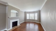 This well-appointed two-bedroom, two-bathroom home in Memphis, Tennessee offers a thoughtfully designed single-floor layout that balances classic charm with everyday functionality. Rich hardwood floors run throughout the main living areas and bedrooms, complemented by crisp white crown molding and neutral taupe walls that create a warm, cohesive ambiance.

The living room serves as the heart of the home, highlighted by a decorative fireplace with an arched mirror surround and a tiled hearth, alongside a graceful bay window that invites natural light. An adjacent room with additional windows provides flexible space ideal for dining or a secondary sitting area.

Both bedrooms feature the same warm hardwood flooring, crown molding, and natural light from multiple windows with blinds. One bedroom includes a ceiling fan and dual windows, while the other offers a walk-in closet for added storage convenience.

The kitchen is equipped with white cabinetry, granite-look countertops, a double basin sink, a gas range, and a dishwasher, all brightened by a wide bank of windows overlooking greenery. The bathrooms include classic white subway tile wainscoting, hexagonal mosaic floor tile, and a shower-tub combination. A stacked washer and dryer unit provides in-unit laundry, adding practical convenience to this charming Memphis residence.