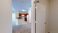 Located at 8100 Claire Ann Dr in Orlando, FL, this 2-bedroom, 2-bathroom residence offers a well-designed single-floor layout that maximizes functionality and comfort. The open-concept kitchen and living area forms the heart of the home, featuring warm wood cabinetry, a peninsula breakfast bar with a rich countertop, tile flooring, and white appliances including a refrigerator, range, and built-in microwave. The living room impresses with vaulted ceilings and a ceiling fan, creating an airy, spacious ambiance, and is highlighted by a sliding glass door that fills the room with natural light and provides views of the surrounding community. Both bedrooms are carpeted and generously proportioned, with the primary bedroom offering a walk-in closet outfitted with wire shelving, a ceiling fan, and a dedicated window. Each bathroom includes a wood-toned vanity with storage, tile flooring, and a tub-shower combination. A dedicated laundry room houses a full-size washer and dryer with overhead wire shelving for added storage. Throughout the residence, neutral tones, plush carpet, and clean white trim contribute to a bright, move-in-ready atmosphere.