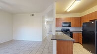 Located in Gilbert, AZ, this 2-bedroom, 2-bathroom single-floor residence offers a practical and comfortable layout designed for everyday living. The open-concept kitchen and living area serves as the heart of the home, featuring light tile flooring, a peninsula with dark granite-style countertops, warm wood-toned cabinetry, and black appliances including a range, over-the-range microwave, refrigerator, and dishwasher. The living area is bright and airy, with a ceiling fan and a sliding glass door that opens to a private patio, allowing natural light to fill the space.

Both bedrooms are carpeted and include ceiling fans for year-round comfort. The primary bedroom is a generous size and features a sliding glass door leading to a balcony, providing an additional outdoor retreat. Each bedroom is accompanied by its own closet, with the primary closet offering a walk-in design outfitted with wire shelving and hanging rods for ample storage.

The two bathrooms are finished with tile flooring and include a tub/shower combination with clean, simple fixtures. Additional highlights include a dedicated pantry, an in-unit laundry area, and a hallway connecting the private quarters of the home. The entry foyer features tile flooring and a window, creating a welcoming introduction to the space.