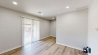 Located at 4020 S 130th East Ave in Tulsa, Oklahoma, this one-bedroom, one-bathroom unit offers a thoughtfully designed layout across a single floor. Light wood-style flooring runs throughout the space, creating a clean, cohesive aesthetic that ties every room together. The living room greets you at the entry, featuring a bright white paneled door, recessed lighting, and a sliding glass door fitted with vertical blinds that allow natural light to filter in and provide access to the outdoors. The space flows openly into the rest of the unit, with neutral gray walls that lend a calm, modern tone. The bedroom is a cozy, well-proportioned retreat with a window dressed in horizontal blinds, allowing for controlled natural light and privacy. The bathroom stands out as a refined highlight, showcasing rich dark-wood cabinetry with brushed nickel hardware, granite-style countertops, and a full tub and shower combination framed by large-format marble-style tile that extends to the ceiling. Wood-style flooring continues here as well, maintaining design consistency. A dedicated laundry area adds everyday convenience. Recessed lighting throughout the unit ensures a well-lit, polished interior, making this a functional and stylish home in the heart of Tulsa.