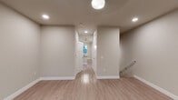 Located at 200 S Vine St in Urbana, Illinois, this thoughtfully designed 3-floor property showcases modern construction with consistent, high-quality finishes throughout. Light-toned hardwood-style flooring flows through the main living and corridor areas, complemented by clean white trim and neutral wall tones that create a bright, welcoming atmosphere.

The kitchen is a standout feature, equipped with rich dark-stained cabinetry, stainless steel appliances including a refrigerator, range, and built-in microwave, and striking granite countertops extending to a center island. A classic white subway tile backsplash and statement pendant lighting complete the space with a polished, contemporary look.

Living areas are well-proportioned and filled with natural light from large windows with blinds, and ceiling fans provide comfort throughout. Bedrooms feature plush carpeting, ceiling fans, and multiple closet access points for ample storage. A dedicated entry area provides a clean transition into the home.

Bathrooms are finished with granite-topped dark vanities, hardwood-style flooring, and full tub-shower combinations with brushed nickel fixtures. Additional bathrooms offer shower stalls and clean, minimalist design. Recessed lighting and globe fixtures illuminate the hallways and common areas efficiently. The staircase connects all three levels seamlessly, reinforcing the home's cohesive and functional design.