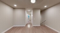 Located at 200 S Vine St in Urbana, Illinois, this thoughtfully designed 3-floor property showcases modern construction with consistent, high-quality finishes throughout. Light-toned hardwood-style flooring flows through the main living and corridor areas, complemented by clean white trim and neutral wall tones that create a bright, welcoming atmosphere.

The kitchen is a standout feature, equipped with rich dark-stained cabinetry, stainless steel appliances including a refrigerator, range, and built-in microwave, and striking granite countertops extending to a center island. A classic white subway tile backsplash and statement pendant lighting complete the space with a polished, contemporary look.

Living areas are well-proportioned and filled with natural light from large windows with blinds, and ceiling fans provide comfort throughout. Bedrooms feature plush carpeting, ceiling fans, and multiple closet access points for ample storage. A dedicated entry area provides a clean transition into the home.

Bathrooms are finished with granite-topped dark vanities, hardwood-style flooring, and full tub-shower combinations with brushed nickel fixtures. Additional bathrooms offer shower stalls and clean, minimalist design. Recessed lighting and globe fixtures illuminate the hallways and common areas efficiently. The staircase connects all three levels seamlessly, reinforcing the home's cohesive and functional design.