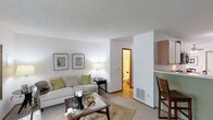 This two-floor residence offers a thoughtfully organized layout designed for comfortable everyday living. The living room serves as the heart of the home, featuring a fireplace, soft carpeting, and a large sliding glass door that frames outdoor views and fills the space with natural light. A glass-top coffee table and generous seating area create an inviting atmosphere.

The kitchen is efficiently designed with ample white cabinetry trimmed in warm wood tones, a double-basin sink, a full appliance suite including a dishwasher and electric range, and light hardwood-style flooring. Adjacent to the kitchen, the dining area features a ceiling fan, a window for natural light, and enough space for a round dining table with seating for four.

The bedrooms are carpeted and well-proportioned, each with windows allowing natural light. The primary bedroom benefits from vaulted ceilings, lending a sense of openness. The primary bathroom includes a double-sink vanity and a walk-in shower with glass enclosure. A second bathroom features a single vanity with a large mirror and elegant lighting. Throughout the home, textured ceilings, warm wood trim, and neutral tones create a cohesive and welcoming aesthetic across both floors.