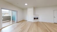Located at 4704 Center Street NE in Salem, Oregon, this well-appointed 2-bedroom, 2-bathroom residence offers a thoughtfully designed single-level layout. The open-concept living, dining, and kitchen area forms the heart of the home, anchored by light-toned hardwood flooring that flows throughout the main spaces. A modern wall-mounted fireplace adds a clean, contemporary focal point to the living room, which also features a sliding glass door opening onto a private balcony with outdoor views.

The kitchen is outfitted with rich, dark-stained cabinetry, stainless steel appliances including a refrigerator, range, and microwave, and a white countertop peninsula with bar seating. Pendant lighting and a wall-mounted mini-split system complete the space. A built-in pantry cabinet adds practical storage.

Both bedrooms feature plush carpeting, natural light from window blinds with outdoor views, and ceiling fans. The primary bedroom connects directly to one of the two bathrooms, which features a wide vanity with a large mirror. The second bathroom includes a full tub-shower combination. Additional highlights include multiple closets, an in-unit laundry area, and a clean, neutral palette throughout that creates a bright and welcoming ambiance.