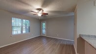 Located at 100 Windmont Dr NE in Brookhaven, GA, this single-floor unit offers a practical and well-appointed layout designed for comfortable everyday living. The open-concept living area is finished with durable hardwood-style flooring and neutral gray walls, creating a clean and versatile backdrop. A ceiling fan with a light kit provides both comfort and illumination, while multiple windows with slatted blinds allow natural light to filter in alongside views of surrounding greenery. A door off the living area provides direct outdoor access.

The kitchen is outfitted with crisp white cabinetry, granite countertops, a subway tile backsplash, and stainless steel appliances including a range, microwave, refrigerator, and dishwasher. A peninsula with an undermount sink opens toward the living space, reinforcing the open-concept flow.

The bedroom features plush carpeting, a ceiling fan, and a window overlooking lush trees, offering a quiet and comfortable retreat. The bathroom includes a full tub-shower combination with white tile surround, granite-topped vanity, and a large mirror. A textured ceiling is consistent throughout the unit, adding a classic residential character to the space.