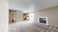 Located at 3101 SW Twilight Ct in Topeka, Kansas, this single-floor residence offers a functional and comfortable layout throughout. The open living area serves as the heart of the home, featuring plush wall-to-wall carpeting, a white-surround fireplace, and sliding glass doors with vertical blinds that allow natural light to fill the space. A ceiling fan adds to the room's practicality and comfort.

The kitchen is efficiently designed in a galley configuration, with white cabinetry, light granite-style countertops, wood-look vinyl flooring, and white appliances including an electric range and refrigerator. It flows conveniently from the main living space.

The bedrooms are carpeted and finished in neutral warm tones, each featuring windows with blinds that bring in natural light. At least one bedroom includes a dedicated closet with shelving, while another provides access to additional storage. The rooms offer generous proportions suitable for a variety of furniture arrangements.

The bathroom is clean and well-appointed, featuring a tiled tub-and-shower combination, wood-look vinyl flooring, a vanity with under-sink storage, and a toilet. Textured ceilings are consistent throughout the home, contributing to its classic, understated character. Overall, the space presents a neutral, move-in-ready aesthetic well-suited for everyday living.