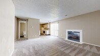 Located at 3101 SW Twilight Ct in Topeka, Kansas, this single-floor residence offers a functional and comfortable layout throughout. The open living area serves as the heart of the home, featuring plush wall-to-wall carpeting, a white-surround fireplace, and sliding glass doors with vertical blinds that allow natural light to fill the space. A ceiling fan adds to the room's practicality and comfort.

The kitchen is efficiently designed in a galley configuration, with white cabinetry, light granite-style countertops, wood-look vinyl flooring, and white appliances including an electric range and refrigerator. It flows conveniently from the main living space.

The bedrooms are carpeted and finished in neutral warm tones, each featuring windows with blinds that bring in natural light. At least one bedroom includes a dedicated closet with shelving, while another provides access to additional storage. The rooms offer generous proportions suitable for a variety of furniture arrangements.

The bathroom is clean and well-appointed, featuring a tiled tub-and-shower combination, wood-look vinyl flooring, a vanity with under-sink storage, and a toilet. Textured ceilings are consistent throughout the home, contributing to its classic, understated character. Overall, the space presents a neutral, move-in-ready aesthetic well-suited for everyday living.
