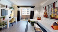 Located in the heart of Downtown Los Angeles, this thoughtfully designed 2-bedroom, 2-bathroom residence offers a functional and stylish single-floor layout. The open-concept living, dining, and kitchen area serves as the centerpiece of the home, featuring crown molding, wood-style flooring, and a sliding glass door that leads to a private balcony with urban skyline views. The living room is bright and airy, benefiting from generous natural light. The kitchen is well-equipped with rich dark wood cabinetry, granite countertops, a subway tile backsplash, stainless steel appliances including a gas range, and recessed lighting beneath a tray ceiling. The spacious primary bedroom accommodates a large bed comfortably and includes its own closet, while the second bedroom is equally versatile. Both bathrooms feature dark wood vanities with granite countertops, tiled flooring, and tub-shower combinations with glass sliding doors. Additional highlights include four closets providing ample storage, an in-unit stacked washer and dryer, and a dedicated dining area. The balcony offers an ideal outdoor retreat with city views, completing this well-rounded Downtown LA residence.