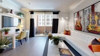 Located in the heart of Downtown Los Angeles, this thoughtfully designed 2-bedroom, 2-bathroom residence offers a functional and stylish single-floor layout. The open-concept living, dining, and kitchen area serves as the centerpiece of the home, featuring crown molding, wood-style flooring, and a sliding glass door that leads to a private balcony with urban skyline views. The living room is bright and airy, benefiting from generous natural light. The kitchen is well-equipped with rich dark wood cabinetry, granite countertops, a subway tile backsplash, stainless steel appliances including a gas range, and recessed lighting beneath a tray ceiling. The spacious primary bedroom accommodates a large bed comfortably and includes its own closet, while the second bedroom is equally versatile. Both bathrooms feature dark wood vanities with granite countertops, tiled flooring, and tub-shower combinations with glass sliding doors. Additional highlights include four closets providing ample storage, an in-unit stacked washer and dryer, and a dedicated dining area. The balcony offers an ideal outdoor retreat with city views, completing this well-rounded Downtown LA residence.