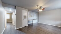 Located at 2804 Dewey Ave in Norman, Oklahoma, this single-story home accommodates four bedrooms and one bathroom within a compact, efficiently arranged floor plan. Consistent wood-style plank flooring runs throughout the entire home, lending a cohesive, clean aesthetic to every room.

The living room serves as the social hub of the home, highlighted by a ceiling fan with light fixture and a distinctive built-in unit featuring open shelving, cabinetry, and a wood-topped bench — a functional and characterful design element. A window provides natural light, while neutral gray walls complement the flooring throughout.

The galley-style kitchen is lined with white cabinetry, dark granite-style countertops, and includes a full suite of appliances — electric range, refrigerator, dishwasher, and overhead ventilation. Its efficient linear layout maximizes the available space.

The four bedrooms are each finished with the same wood-style flooring and neutral wall tones. Several rooms feature windows with blinds that bring in natural light and outdoor views of surrounding greenery. The primary bedroom offers a comfortable footprint relative to the overall home.

The bathroom includes a vanity with dark countertop, a tub/shower combo, and a medicine cabinet mirror. A dedicated laundry room adds practical everyday convenience.