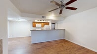 Located at 234 N 75th St in Mesa, AZ, this single-level 1-bedroom, 1-bathroom unit offers a well-organized and functional layout. The open-concept living, dining, and kitchen area forms the heart of the home, featuring warm hardwood-style flooring and a ceiling fan that enhances air circulation throughout. The kitchen is equipped with warm-toned wood cabinetry, granite-look countertops, a full suite of white appliances including an electric range, microwave, and refrigerator, and a raised breakfast bar peninsula that separates the kitchen from the living space. Track lighting above the kitchen adds a modern touch, while a recessed ceiling detail provides architectural interest. The living area receives natural light through a front-facing window and includes direct access to the entry door. The bedroom is a comfortable, well-lit space with carpeted flooring, two windows that invite ample natural light, and a ceiling fan. A dedicated closet provides storage. The bathroom features a full tub/shower combo with chrome fixtures, wood cabinetry, and hardwood-style flooring. In-unit laundry hookups offer added convenience. A private balcony rounds out this thoughtfully designed home.