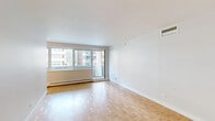 Located at 3450-3460 Rue Drummond in Montréal's prestigious Golden Square Mile neighbourhood, this well-appointed one-bedroom, one-bathroom unit offers a thoughtfully designed layout across a single floor. The living area is bright and open, showcasing classic parquet wood flooring in a herringbone-style pattern that adds warmth and character throughout. Large windows allow natural light to fill the space and provide views of the surrounding urban streetscape, with access to a balcony extending the living area outdoors.

The kitchen is designed in a galley configuration, featuring crisp white cabinetry, dark granite countertops, a white subway tile backsplash, and stainless steel appliances including a refrigerator, stove, and built-in microwave — a clean, functional space ideal for everyday cooking.

The generously sized primary bedroom continues the parquet flooring and offers ample room for furnishings, with access to the hallway and closet space. The bathroom is finished to a modern standard, with a double-sink vanity topped in dark granite, floating white cabinetry, recessed lighting, and a glass-enclosed walk-in shower. Charming barn-style sliding doors add a distinctive design touch to the storage cabinetry. Overall, the unit presents a clean, contemporary aesthetic in a highly sought-after Montréal location.