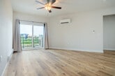 Located on Central Park Place in Fitchburg, WI, this thoughtfully designed one-bedroom, one-bathroom residence offers a clean, modern aesthetic throughout. The open-concept kitchen and living area serves as the heart of the home, showcasing light-toned hardwood flooring, crisp white walls, and abundant natural light. The kitchen is outfitted with rich dark-wood cabinetry, a full suite of stainless steel appliances—including a refrigerator, microwave, and range—and a spacious island with a white quartz countertop, double sink, and stylish pendant lighting overhead. The living area flows effortlessly toward sliding glass doors that open to a private patio, with a ceiling fan and baseboard heating ensuring year-round comfort. A wall-mounted mini-split unit provides additional climate control. The bedroom features plush carpeting, a ceiling fan, a bright window with outdoor views, and direct access to a walk-in closet with built-in shelving. The bathroom includes a walk-in shower with built-in storage. Additional conveniences include a dedicated pantry and in-unit laundry. Light-filled hallways with hardwood floors connect each space, lending the home a cohesive, airy feel throughout.