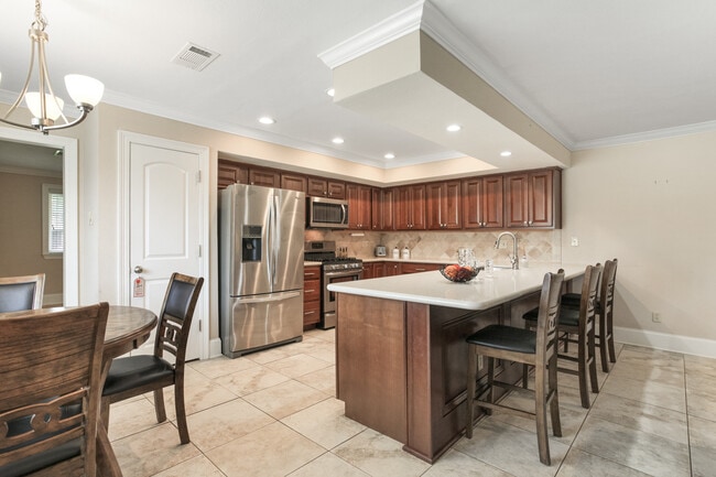 Open concept kitchen/living area with stone countertops, gas range, SS appliances and breakfast area - 5012 Antonini Dr