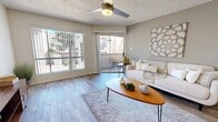 This thoughtfully designed 1-bedroom, 2-bathroom residence offers an efficient and functional single-floor layout that maximizes every square foot. Wood-look flooring flows consistently throughout the space, tying each room together with a clean, modern aesthetic.

The open-concept living area is bright and welcoming, anchored by large sliding glass doors and a full-width window that flood the space with natural light and provide direct access to a private balcony with outdoor views. A ceiling fan adds a practical touch overhead, while textured ceilings add character throughout.

The kitchen features white cabinetry, a mosaic tile backsplash, a peninsula with countertop seating, and black appliances including a range and refrigerator. Track lighting illuminates the workspace effectively. The adjacent dining area offers a defined nook, ideal for intimate meals.

The bedroom is a comfortable retreat with a sliding glass door to a second outdoor area, vertical blinds for light control, and a dedicated closet. Two full bathrooms serve the unit — one featuring a vanity with light countertops and white cabinetry, the other with a shower/tub combination. The entryway provides a welcoming transition into the home with ample wall space and clean sightlines throughout.