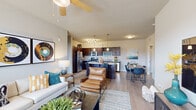 This two-bedroom, two-bathroom single-story residence at Grand Courtyard in Memphis, Tennessee offers a thoughtfully designed open-concept layout that seamlessly connects the living, dining, and kitchen areas. Wood-style flooring flows throughout the main living spaces, contributing to a clean, contemporary aesthetic.

The living room is bright and welcoming, featuring large windows that invite natural light and a ceiling fan overhead. The kitchen is a functional centerpiece of the home, equipped with dark espresso cabinetry, granite countertops, stainless steel appliances including a refrigerator, range, microwave, and dishwasher, and a spacious island with bar seating and pendant lighting above.

Both bedrooms are comfortably sized and feature large windows with outdoor views, ceiling fixtures, and plush carpeting. Each is paired with its own full bathroom, finished with dark wood vanities, granite countertops, and a shower/tub combination.

A dedicated in-unit laundry closet accommodates a full-size washer and dryer, adding everyday convenience. The overall ambiance throughout is modern and cohesive, with neutral tones providing a versatile backdrop throughout this well-appointed Memphis residence.