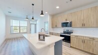 Located in Lewisville, TX, this thoughtfully designed 2-bedroom, 2-bathroom residence offers a clean, contemporary aesthetic throughout. Light hardwood-style flooring flows seamlessly across the entire single-floor layout, creating a cohesive and inviting atmosphere.

The kitchen serves as the heart of the home, anchored by a large island with a crisp white countertop and an integrated sink, illuminated by stylish pendant lights. Light wood-tone cabinetry extends to the ceiling, complemented by a classic white subway tile backsplash and stainless steel appliances, including a range, microwave, and refrigerator.

Both bedrooms are bright and airy, each featuring ceiling fans and large windows that invite abundant natural light and outdoor views. Each bedroom is paired with its own dedicated closet, offering generous storage with built-in shelving and hanging rods. One bedroom features a spacious walk-in closet with multi-level shelving on three sides.

The two bathrooms maintain the home's consistent modern style, each featuring warm wood-toned vanity cabinetry, white countertops, and the same light hardwood-style flooring. One bathroom includes a soaking tub with tile surround, while the other offers a streamlined layout with a well-appointed vanity and direct closet access. The overall ambiance is bright, clean, and move-in ready.