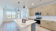 Located in Lewisville, TX, this thoughtfully designed 2-bedroom, 2-bathroom residence offers a clean, contemporary aesthetic throughout. Light hardwood-style flooring flows seamlessly across the entire single-floor layout, creating a cohesive and inviting atmosphere.

The kitchen serves as the heart of the home, anchored by a large island with a crisp white countertop and an integrated sink, illuminated by stylish pendant lights. Light wood-tone cabinetry extends to the ceiling, complemented by a classic white subway tile backsplash and stainless steel appliances, including a range, microwave, and refrigerator.

Both bedrooms are bright and airy, each featuring ceiling fans and large windows that invite abundant natural light and outdoor views. Each bedroom is paired with its own dedicated closet, offering generous storage with built-in shelving and hanging rods. One bedroom features a spacious walk-in closet with multi-level shelving on three sides.

The two bathrooms maintain the home's consistent modern style, each featuring warm wood-toned vanity cabinetry, white countertops, and the same light hardwood-style flooring. One bathroom includes a soaking tub with tile surround, while the other offers a streamlined layout with a well-appointed vanity and direct closet access. The overall ambiance is bright, clean, and move-in ready.