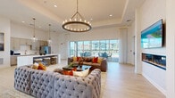 Located at 2500 Peaceful River Dr in Mount Dora, Florida, this sophisticated single-story clubhouse offers a generous and thoughtfully designed interior spread across one expansive level. The grand entrance foyer immediately impresses with soaring double-height ceilings, intricate parquet-style wood flooring, and statement brass lantern chandeliers that set a refined tone throughout. Floor-to-ceiling windows flood the space with abundant natural light, framing views of the surrounding community and pool area.

The main lounge features tray ceilings, a sleek linear fireplace, light wood flooring, and stylish seating arrangements anchored by a striking circular chandelier. A second formal sitting area with a dramatic two-story window wall offers an airy, open ambiance ideal for gathering. The space flows seamlessly into a well-appointed kitchen equipped with stone countertops, a large marble-topped island with bar seating, pendant lighting, and stainless steel appliances — all accessible to an outdoor terrace.

Multiple dining areas provide flexible seating options, including a banquette nook bathed in natural light and a private room with sage-green panel walls and a wall-mounted display. Glass-paned corridor doors and light, neutral finishes throughout contribute to the space's cohesive, modern-coastal aesthetic.