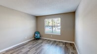 Located along SR-A1A in Jacksonville, Florida, this single-story, 2-bedroom, 1-bathroom residence offers a well-organized and functional layout. The living area features warm wood-style flooring that extends through the main living spaces, complemented by neutral-toned walls and a textured ceiling. Natural light flows in through multiple windows fitted with horizontal blinds, creating a bright and comfortable atmosphere throughout.

The kitchen is thoughtfully designed with white shaker-style cabinetry, light quartz countertops, a teal glass tile backsplash, and black appliances including a range, microwave, refrigerator, and dishwasher. A stainless steel sink completes the functional workspace.

Both bedrooms are carpeted and receive natural light through windows with outdoor views. The primary bedroom features access to a dedicated walk-in closet equipped with wire shelving for organized storage. The shared bathroom includes a tub-shower combination, a white vanity with a light countertop, and wood-look tile flooring.

A dedicated laundry area accommodates a full-sized top-load washer with overhead wire shelving for added utility. The hallway connects all rooms efficiently, and the entry area features durable wood-style flooring with a recessed ceiling light, providing a clean and welcoming introduction to the home.