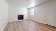 Located at 2975 Main St in Kansas City, MO, this one-bedroom, two-bathroom residence offers a well-designed single-floor layout that maximizes every square foot of its compact footprint. Light wood-style flooring runs throughout the main living areas, creating a cohesive and contemporary feel.

The kitchen is a standout feature, outfitted with gray shaker-style cabinetry accented by gold hardware, granite-style countertops, a classic white subway tile backsplash, and a full suite of stainless steel appliances. A peninsula provides additional counter space and serves as a natural divider between the kitchen and the adjacent living area.

The living room is bright and inviting, anchored by a tile-surround fireplace with a white mantle and complemented by light-toned hardwood-style flooring and a textured ceiling. Natural light filters in through a window, adding to the airy ambiance.

The spacious primary bedroom features plush carpeting, a generous closet, and direct access to a private en-suite bathroom. A second full bathroom with a tub/shower combination and safety grab bars offers additional convenience. Throughout the unit, clean white walls and neutral finishes create a calm, move-in-ready atmosphere.