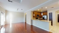 Located at 3410 Alexander Rd in Atlanta, GA 30326, this single-floor residence offers a well-designed layout with thoughtful finishes throughout. The open-concept living and dining area is anchored by rich, glossy hardwood floors that reflect natural light from multiple windows. Crown molding adds a refined architectural detail, and a tray ceiling lends a sense of elevated volume to the main living space.

The kitchen opens seamlessly to the living area via a peninsula counter with granite countertops, pendant lighting, and ample warm-toned wood cabinetry. Stainless steel appliances — including a range, microwave, refrigerator, and dishwasher — are complemented by a tile backsplash and light ceramic tile flooring, creating a functional and polished cooking environment.

A hallway with arched doorways connects the living spaces to the bedrooms, each finished with plush carpeting, neutral walls, and natural light from windows with blinds. The bathrooms feature warm wood vanities with granite-style countertops and ceramic tile flooring. One bathroom includes a full soaking tub surrounded by classic stone-look tile with a decorative accent border.

Overall, the space presents a clean, neutral palette with consistent, quality finishes that create a comfortable and welcoming atmosphere throughout.