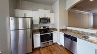 Located at 931 Slateworth Dr in Durham, NC, this three-story home offers a thoughtfully designed layout spread across multiple levels. The main living area welcomes you with plush carpeting, crown molding, and a ceiling fan, with natural light streaming in through windows that overlook the surroundings. A staircase with a wood railing connects the floors, with well-lit hallways guiding the transition between levels.

The kitchen is outfitted with stainless steel appliances — including a refrigerator, electric range, built-in microwave, and dishwasher — complemented by white shaker-style cabinetry and granite-toned countertops. Rich hardwood flooring grounds the kitchen and extends into the adjacent areas, adding warmth to the space.

Bathrooms throughout the home are finished consistently, featuring white cabinetry with granite countertops, undermount sinks, and hardwood flooring. The half bath on the main level provides convenient access for guests, while upper-level bathrooms offer additional privacy.

The bedrooms are carpeted and generously proportioned, with vaulted or elevated ceilings in some rooms enhancing the sense of space. Neutral gray walls throughout the home provide a clean, versatile backdrop. Overall, this multi-level residence combines functional design with cohesive finishes across every floor.