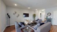 This single-floor residence offers a thoughtfully designed open-concept layout that seamlessly connects the main living areas. The spacious living room is anchored by warm hardwood flooring, recessed lighting, and neutral-toned walls, creating a bright and welcoming atmosphere. Large windows in the living area allow natural light to pour in, while a wall-mounted flat-screen television serves as a focal point.

The kitchen is well-equipped with stainless steel appliances, including a gas range, microwave, and refrigerator, complemented by white cabinetry, granite countertops, and pendant lighting above the island. A deep undermount sink and dishwasher add to its functionality.

Adjacent to the kitchen, the dining area features multiple windows that flood the space with natural light and provide exterior views, making it an inviting setting for meals.

The bedrooms are carpeted for comfort, with the primary bedroom benefiting from a generous bank of windows. The primary bathroom includes a glass-enclosed walk-in shower, a soaking tub, tile flooring, and a vanity with granite countertops. An additional bathroom with tile flooring provides convenience for other occupants. Throughout the residence, clean lines, neutral tones, and quality finishes contribute to a cohesive and modern aesthetic.