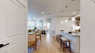 This thoughtfully designed 2-bedroom, 2-bathroom single-story residence offers a comfortable and functional open-concept floor plan. Light wood flooring flows seamlessly through the main living areas, creating a bright and cohesive aesthetic throughout.

The kitchen serves as a central hub of the home, featuring sage-toned cabinetry, a white subway tile backsplash, stainless steel appliances, and a granite-topped island with bar seating illuminated by elegant pendant lighting. A built-in desk nook and open shelving add both practicality and character.

The open layout connects the kitchen to the dining area and a spacious living room, which is bathed in natural light from large windows and features a ceiling fan and direct access to an exterior door.

The primary bedroom offers a generous footprint with plush carpeting, ample natural light, and a ceiling fan. It is complemented by a walk-in closet with multi-level shelving and a private en-suite bathroom showcasing dual granite vanities, gray cabinetry with matte black hardware, and a glass-enclosed shower. The second bedroom is equally bright and comfortable, with carpeted flooring, large windows, and its own closet. Additional spaces include a laundry room, pantry, and a connecting hallway, rounding out a well-organized and livable floor plan.