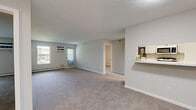 Located at 11445 Anderson Lakes Pkwy in Eden Prairie, Minnesota, this single-floor, three-bedroom, two-bathroom residence offers a practical and comfortable layout. The open-concept living area features neutral-toned carpeting, a textured ceiling, and a window that allows natural light to fill the space. A pass-through shelf connects the living area to the kitchen, which is equipped with white cabinetry, stainless steel appliances including a refrigerator and range, and durable hard-surface flooring.

The primary bedroom is a generously sized room featuring carpet flooring, a wall-mounted air conditioning unit, a baseboard heating system, and a window with outdoor views. The two additional bedrooms are well-proportioned, each carpeted and fitted with baseboard heating and ceiling fans for year-round comfort. A carpeted hallway with panel-style doors leads to a full bathroom featuring hexagonal tile flooring, a white vanity with ample cabinetry, and a tub-shower combination. A second full bathroom also includes a tub-shower combo. The unit further includes a dedicated closet and in-unit laundry, adding to the overall convenience and functionality of the space.