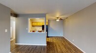 Located at 5028 Dierker Rd in Columbus, Ohio, this single-floor unit offers a well-organized layout with a consistent, neutral color palette throughout. Dark hardwood-style flooring runs through the main living areas, hallways, and kitchen, providing a cohesive and polished look.

The living room is generously sized, featuring a ceiling fan with light fixture and a large window that allows natural light to fill the space. A distinctive pass-through window connects the living area to the kitchen, creating an open, communicative feel between the two spaces. The galley-style kitchen is equipped with warm wood cabinetry, light countertops, a gas range, and a full-size refrigerator, with ample upper and lower cabinet storage on both sides.

The hallway entry connects to the main living spaces and features a textured ceiling and flush-mount lighting. The bathroom includes a wood-toned vanity with a marble-style countertop, a single sink, and a wall-mounted mirror with overhead lighting. The bedrooms are carpeted for comfort and include windows with blinds that provide natural light and outdoor views. One bedroom features a walk-in closet with built-in shelving, adding practical storage. The overall design is clean, functional, and move-in ready.