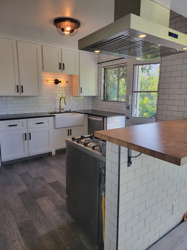 Decorator tile floor in kitchen, stainless steel stove & oven, butcher block counter pass thru - 1451 12th St