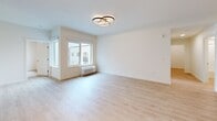 Located at 4001 198th St SW in Lynnwood, WA, this well-appointed three-bedroom, two-bathroom residence offers a thoughtfully designed single-floor layout with a clean, modern aesthetic throughout. Light wood-tone flooring runs continuously across the space, complementing bright white walls and creating a warm, cohesive atmosphere.

The open-concept kitchen is a standout feature, showcasing two-tone cabinetry with light wood uppers and muted gray lowers, white quartz countertops, a tiled backsplash, and a full suite of stainless steel appliances including a refrigerator, electric range, and over-the-range microwave. A kitchen island provides additional prep and dining space.

The living room receives natural light through a large sliding window and is accented by a contemporary circular ceiling light fixture. The entry hallway is bright and open, offering a welcoming transition into the main living areas.

Each of the three bedrooms features light flooring and windows with exterior views. One bedroom includes a stylish sliding barn door. The two bathrooms are finished in a clean, neutral palette — one includes a full soaking tub and shower combination with brushed nickel fixtures, while the second features a modern vanity with a white countertop. The overall design emphasizes simplicity, functionality, and contemporary style.