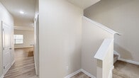 This two-story home offers a thoughtfully designed layout across two floors, providing ample space for comfortable living. The ground floor houses the kitchen and living room, an attached garage with an automatic opener and electrical panel, and a hallway connecting the main areas. The kitchen is a standout feature, appointed with white shaker cabinets, granite countertops, light hardwood-style flooring, and stainless steel appliances, creating a clean and functional space.

The upper floor hosts all three bedrooms, four full bathrooms, two closets, and a dedicated laundry room. The generously sized primary bedroom features light hardwood-style flooring and a ceiling fan, with access to two separate doors — ideal for an en-suite and walk-in closet arrangement. The walk-in closet is outfitted with wire shelving and carpeted flooring for added comfort. The secondary bedrooms feature plush carpeting and natural light from large windows, with one room showcasing charming vaulted ceilings. The bathrooms are finished with white cabinetry, broad vanity mirrors, and tub-shower combos. The laundry room includes overhead wire shelving and dedicated washer/dryer hookups. Neutral warm tones and light flooring throughout lend the home a cohesive, inviting ambiance.