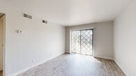 Located on W Main St in Mesa, Arizona, this single-floor residence offers two bedrooms, two bathrooms, and a well-considered layout that maximizes functionality. The open-concept kitchen is a standout feature, appointed with white shaker cabinetry, light quartz countertops, a gray subway tile backsplash, and a full suite of stainless steel appliances including a range, over-the-range microwave, and refrigerator. A peninsula with a deep undermount sink provides additional prep space and separates the kitchen from the living area. Light wood-style plank flooring flows throughout the main living areas, complementing the bright, neutral color palette. The living room is filled with natural light from a sliding glass door fitted with vertical blinds and a security gate, opening to an outdoor area. Both bedrooms feature plush carpet, ample closet space with sliding doors, and windows that bring in natural light. The two bathrooms are clean and functional, each offering a tub/shower combination with chrome fixtures and wood-style tile flooring. A dedicated in-unit laundry area houses a full-size Whirlpool washer and dryer. The overall aesthetic is modern and move-in ready, with a cohesive, updated design throughout.
