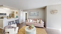 Located at 2155 Great Blue Dr. in Naples, FL, this well-appointed 2-bedroom, 2-bathroom unit offers a thoughtfully designed single-floor layout. The open-concept living and dining area is anchored by wood-look flooring and a textured ceiling, creating a warm, cohesive atmosphere. The living room provides comfortable gathering space, flowing seamlessly into the kitchen and a bright dining nook filled with natural light from large windows and outfitted with a ceiling fan.

The kitchen features crisp white shaker cabinetry, light countertops, a classic subway tile backsplash, and a full suite of stainless steel appliances including a range, over-the-range microwave, and refrigerator. A breakfast bar adds casual dining convenience.

Both bedrooms are comfortably sized, each with ceiling fans, natural light from windows with blinds, and wood-look flooring. The primary bedroom includes an en-suite bathroom with a tub-shower combination. The second bedroom offers access to its own walk-in closet with built-in shelving. Two full bathrooms serve the unit with clean, functional finishes.

A dedicated in-unit laundry area houses a full-size washer and dryer, adding everyday convenience. With two closets throughout and a neutral color palette, this unit offers practical, move-in-ready living in Naples.