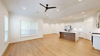 Located at 2654 Aruba Bend Dr in Katy, TX, this modern single-story home offers 3 bedrooms, 4 bathrooms, and a thoughtfully designed open-concept layout. Light wood flooring flows throughout the main living areas, complementing the bright, neutral color palette and recessed lighting overhead.

The open kitchen and living area form the heart of the home, featuring a striking two-tone kitchen island with a white quartz countertop and warm wood cabinetry base. White upper cabinets, stainless steel appliances — including a gas range, microwave, and French door refrigerator — complete the well-appointed kitchen. A ceiling fan anchors the adjacent living space, which benefits from natural light through large windows.

The spacious primary bedroom includes multiple windows, a ceiling fan, and access to a generous walk-in closet with wrap-around shelving and hanging rods. The bathrooms showcase stylish hexagonal white tile with matte black fixtures, adding a contemporary touch. Additional bedrooms are bright and well-sized, each with natural light and wood flooring.

Practical amenities include a dedicated laundry area with a full-size GE washer and dryer, four closets for ample storage, and an attached garage with an automatic opener. This home combines clean, modern design with functional everyday living.