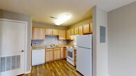 Located at 1904 S Rouse St in Pittsburg, Kansas, this single-floor unit offers a functional and well-organized layout with 2 bedrooms, 2 bathrooms, and a thoughtful use of space throughout. The combined living and dining area provides an open, versatile space for everyday living, featuring warm wood-look vinyl flooring, neutral gray walls, and flush ceiling lighting. This area flows directly into the kitchen, which is well-equipped with light maple cabinetry offering generous upper and lower storage, a double-basin sink, a full suite of white appliances including a refrigerator, electric range, dishwasher, and a range hood. The kitchen continues the wood-look flooring for a cohesive aesthetic. A hallway connects the main living areas to the two bedrooms, each finished with plush carpet and neutral tones. The bedrooms include closets and windows that bring in natural light. Both bathrooms feature clean, white tub-shower combinations with chrome fixtures and durable wood-look flooring. Additional amenities include a utility room, multiple closets distributed throughout the unit, and a dedicated electrical panel. The overall design is clean and practical, making it a comfortable and functional living space.