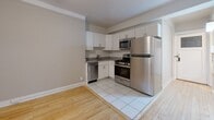 This 390-square-foot apartment in Milwaukee offers a thoughtfully designed living space. The one-bedroom unit maximizes functionality within its compact footprint. The kitchen is a standout feature, boasting modern white cabinetry, stainless steel appliances, and granite countertops. It includes a full-size refrigerator, oven with gas range, dishwasher, and built-in microwave, making it well-equipped for daily cooking needs.

The living area flows seamlessly from the kitchen, with warm hardwood floors creating a cohesive look throughout. The bedroom, measuring 120 square feet, provides ample space for a comfortable sleeping area. Large windows in the living space and bedroom allow natural light to brighten the interior.

The bathroom, while compact, is efficiently designed with a full-size tub, modern fixtures, and a striped shower curtain adding a touch of style. The apartment's layout includes a hallway, likely providing additional storage options.

Overall, this apartment combines modern amenities with a space-efficient design, making it an ideal option for urban living in Milwaukee's vibrant 53202 zip code area.