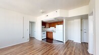 Located on the 5th floor at 1 E 36th St in Indianapolis, this two-bedroom, one-bathroom unit offers a practical and well-organized layout with consistent hardwood-style flooring throughout. The open living area is bright and airy, lined with large windows that invite natural light and offer views of the surrounding neighborhood. The kitchen is seamlessly integrated into the living space via an open pass-through design, featuring warm-toned wooden cabinetry, a double-basin sink, a full-size refrigerator, an electric range, and a dishwasher — providing ample functionality for everyday cooking. The primary bedroom is a generously sized retreat bathed in natural light from a bank of multiple windows, offering a comfortable and open feel. The second bedroom also features a window and dedicated closet storage, making it well-suited as a guest room or home office. Two closets across the unit provide added storage convenience. The bathroom is clean and straightforward, with a full soaking tub, a vanity with wooden cabinetry, and a window that allows for natural ventilation. White walls and neutral tones throughout create a cohesive, move-in-ready atmosphere suited for a range of décor styles.