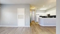 Located at 400 E Glade Rd in Grapevine, TX, this single-floor, 2-bedroom, 2-bathroom residence offers a clean, modern aesthetic with a cohesive design throughout. Wood-look flooring runs continuously across all living areas, complemented by soft gray walls and crisp white trim that give the home a bright, refreshed feel.

The open-concept layout connects the living room directly to the kitchen, which serves as a central feature of the home. The kitchen is equipped with white cabinetry, granite countertops, a bold black subway tile backsplash, and a curved peninsula that provides additional prep and seating space. A skylight above enhances natural light in this area.

A hallway leads to both bedrooms and bathrooms. The primary bedroom is a comfortable size, featuring two windows that allow natural light to fill the room, along with a ceiling fan. The second bedroom is similarly appointed with wood-look flooring and access to the hallway. A dedicated closet provides additional storage.

The two bathrooms are finished with wood-look flooring and white fixtures. One bathroom includes a soaking tub with tiled surround and grab bars, while the second features a walk-in shower, also equipped with accessibility grab bars, offering practical and functional design throughout.