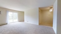 Located at 213 Maple Ave in Horsham, Pennsylvania, this single-floor property offers a clean, functional layout designed for comfortable everyday living. The interior is finished with neutral tones throughout, creating a bright and welcoming atmosphere that provides an excellent canvas for personalization.

The main living area is generously proportioned, featuring soft wall-to-wall carpeting underfoot and smooth white ceilings overhead that contribute to a sense of openness and airiness. A large sliding glass door floods the space with abundant natural light while offering direct views of the surrounding greenery outdoors, seamlessly connecting the interior to the outside environment.

Adjacent to the main living space, a dividing wall with a closeted area suggests a practical transition zone, potentially serving as a hallway or entryway to additional rooms. The light-toned walls and neutral color palette are consistent throughout, lending the space a cohesive and understated aesthetic. Tile flooring is visible in the transitional areas, complementing the carpeted main living space. Overall, the property presents a straightforward, move-in-ready environment with a calm ambiance, ample natural light, and a versatile open layout well-suited to a variety of living arrangements.