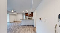 This well-appointed one-bedroom, one-and-a-half-bathroom residence in Cockeysville, MD offers a smart, efficient layout across a single floor. The open-concept kitchen and living area serves as the heart of the home, where rich dark-wood cabinetry, granite countertops, a subway tile backsplash, and a full suite of stainless steel appliances — including a gas range, microwave, and refrigerator — create a polished, functional kitchen. A peninsula with additional counter seating flows naturally into the living area, which is finished with durable wood-style flooring and recessed lighting throughout. Large sliding glass doors in the living room flood the space with natural light and open to views of mature trees and lush greenery, creating a seamless indoor-outdoor connection. The spacious bedroom features plush wall-to-wall carpeting, a ceiling fan, and a generous window with vertical blinds that invite natural light while maintaining privacy. The full bathroom is cleanly finished with a dark wood vanity, white countertop, a mirror with built-in shelving, and open storage shelving alongside. A convenient half-bath provides additional functionality. A dedicated closet and hallway complete this thoughtfully designed home.
